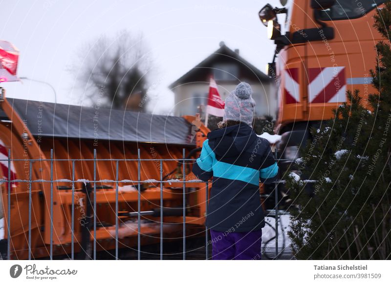 Girl looks at passing winter service vehicle Winter Winter maintenance program Snow Cold Traffic infrastructure Orange Exterior shot paths and paths Observe