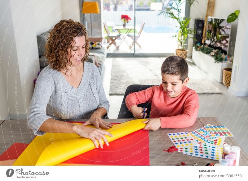 Mother and son  making crafts with cardboards  at home. activity adorable adult birthday birthday crown child childhood classroom colorful creative cut cute