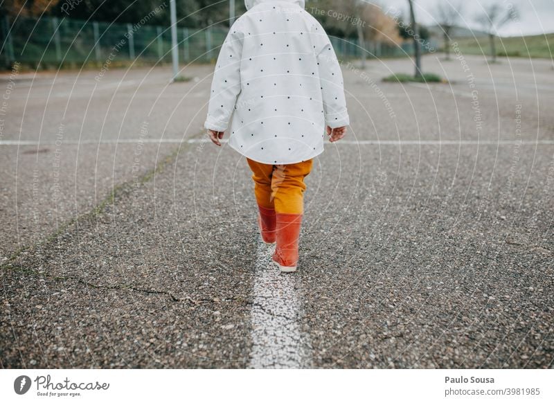 Rear view child walking with red rubber boots Child 1 - 3 years Authentic Red Rubber boots Playing Joy Day Human being Infancy Colour photo Exterior shot