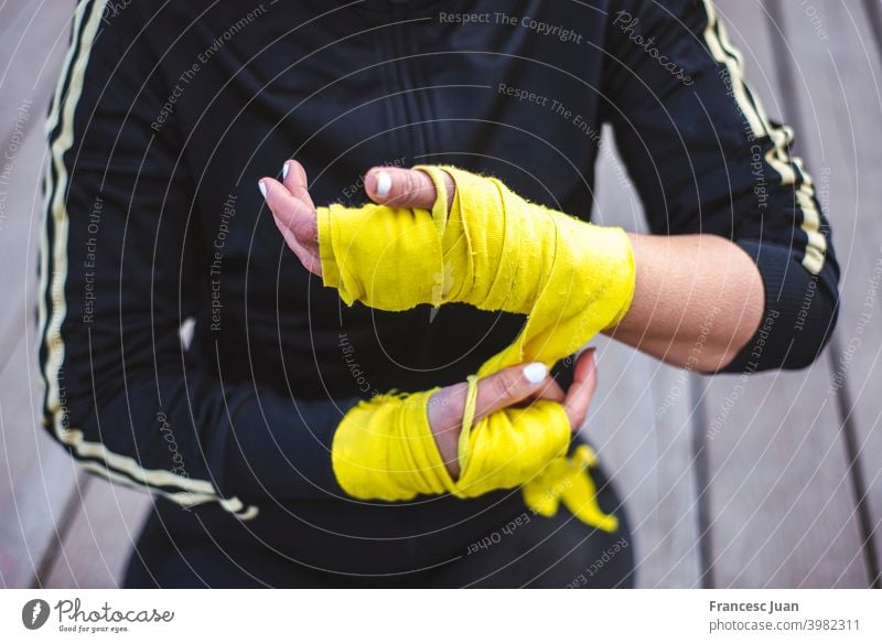 Close-up of fit, woman putting boxing wraps, bandage on her hands. active activity adult arm athlete attractive black body boxer caucasian closeup combat