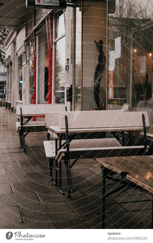 Folded up benches in front of a cafe in Corona winter flipped up Bench tables chairs Café Gloomy Hamburg corona Winter COVID covid-19 closures lock-down