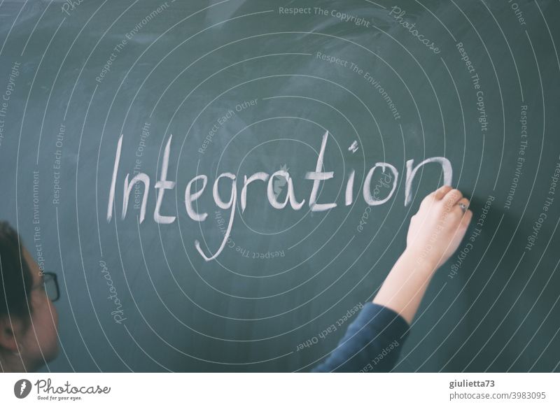 Young teacher writes the word integration on the blackboard with chalk 18-25 years Lessons Day Central perspective Woman Colour photo Green Education Study