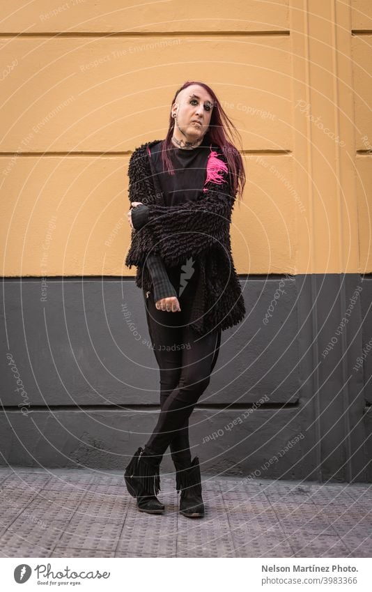 Portrait of an eccentric rocker wearing black clothes. He has long purple hair. androgynous male beautiful young man feminine guy closeup gay photogenic adult