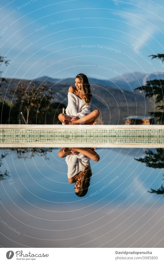 Happy woman resting in yard against mountains happy border tender smile eyes closed daytime sunny sweater positive cheerful glad joy optimist barefoot relax