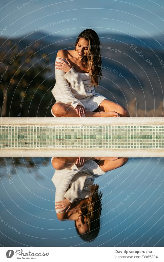 Happy woman resting in yard against mountains happy border tender smile eyes closed daytime sunny sweater positive cheerful glad joy optimist barefoot relax