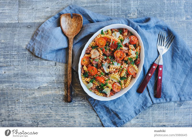 cooking tasty comfort food - italian fusilli pasta baked with meat sauce, cherry tomatoes and cheese lunch dinner plate dish vegetable basil cuisine red cooked