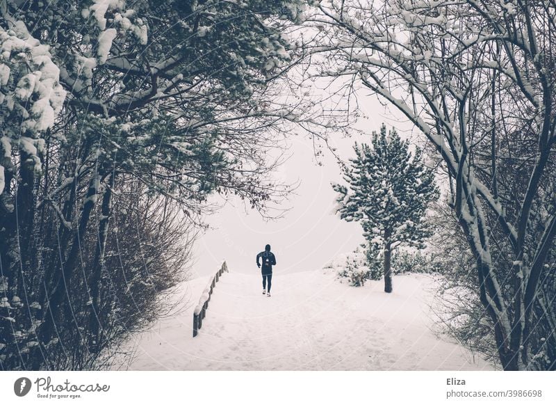 A man jogs through the snow in winter Snow Jogging Walking Sports Winter Man Fitness Movement Athletic Park Nature Snowscape Runner workout Jogger