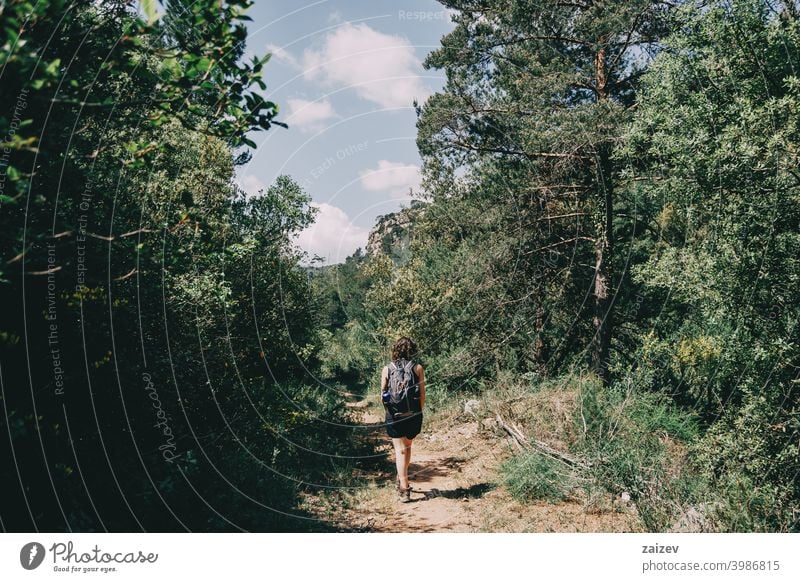 Girl walking along a small path in the mountain of Prades, Tarragona, Spain. la febró prades catalonia spain outdoor medium copy space color people female