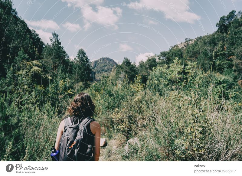 Girl walking along a small path in the mountain of Prades, Tarragona, Spain. la febró prades catalonia spain outdoor medium copy space color people female