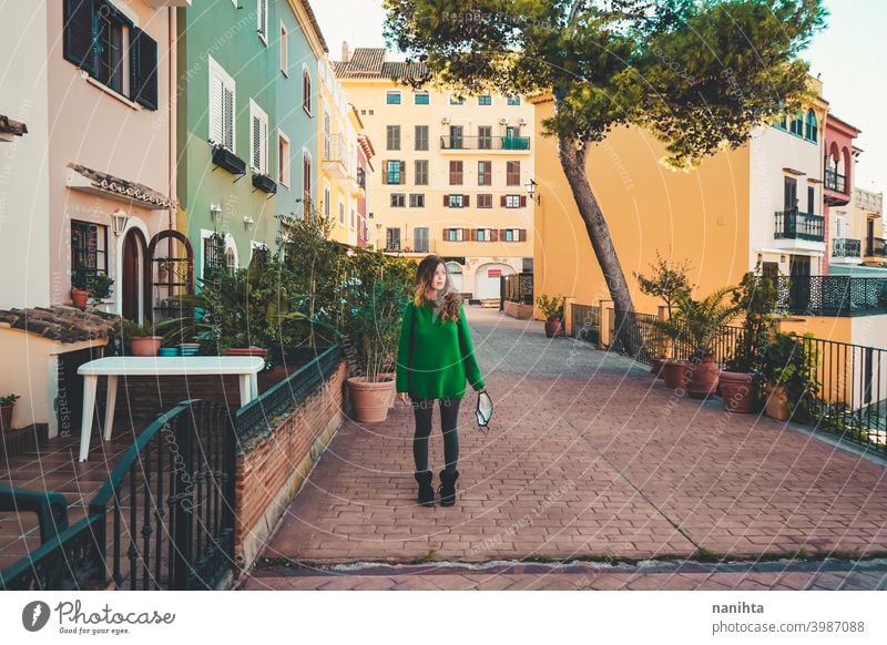 Young woman wearing green oversize sweater enjoying a windy day in a colorful city travel portrait lifestyle model europe european blonde female outdoors free