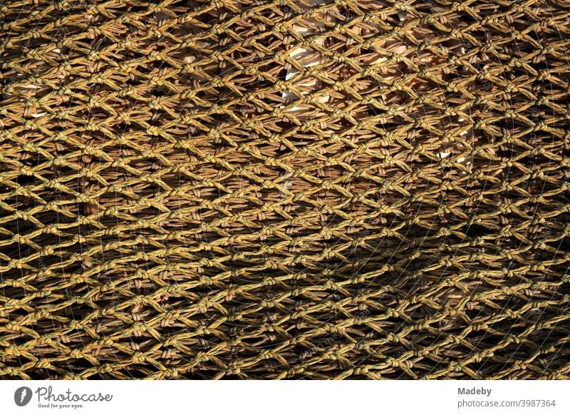 Close-meshed fishing net in the light of the evening sun in the harbour of Dornumersiel at the coast of the North Sea near Esens in East Frisia in Lower Saxony