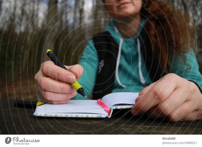 Writing woman in nature Write Woman Nature Notebook hands Forest Inspiration Wooden table hoodie Sweater thinking Diary