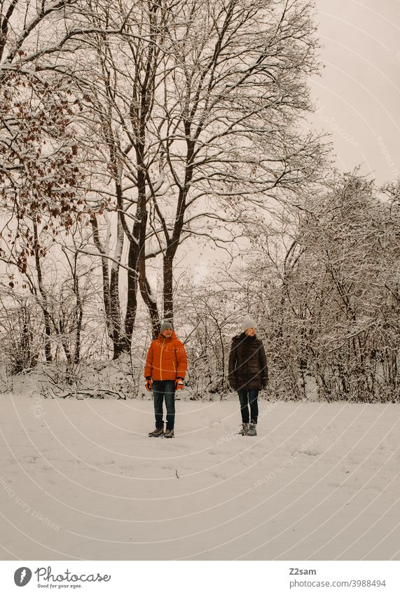 Retired couple in winter landscape To go for a walk Winter Snow chill trees Bushes Woman Man Couple annuity Pensioners relax Relaxation Stand View to the side