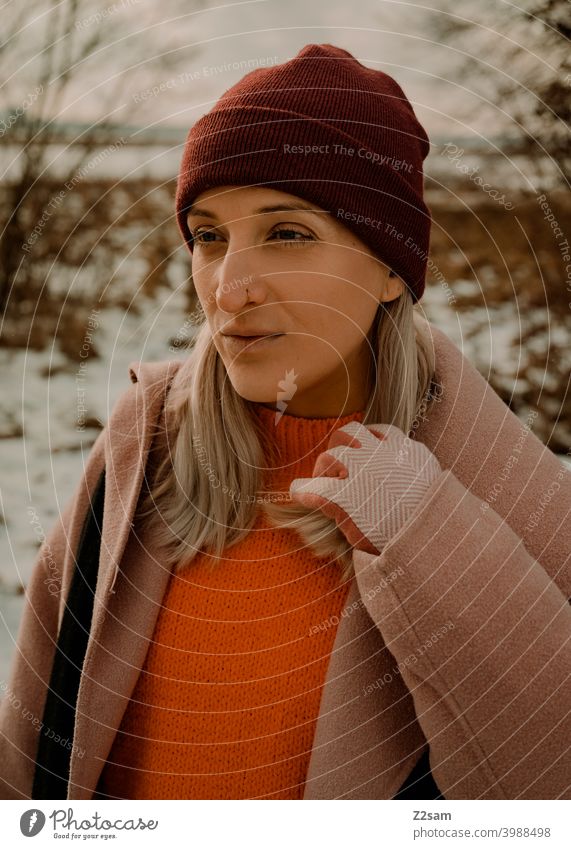 Portrait of a fashionably dressed woman in winter landscape Winter wonderland Woman Young woman Coat To go for a walk Snow Sun Light Nature Landscape Scarf Cap