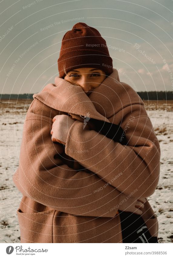 Portrait of a fashionably dressed woman in winter landscape Winter wonderland Woman Young woman Coat To go for a walk Snow Sun Light Nature Landscape Scarf Cap