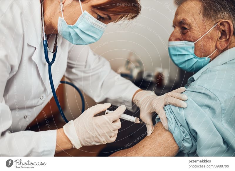 Doctor holding syringe with vaccine and making injection to senior patient. Covid-19 or coronavirus vaccine person vaccination hospital doctor medical medicine