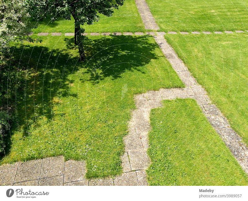 Garden gnomes with stone slabs on green lawn in a park-like garden in summer sunshine in Oerlinghausen near Bielefeld in the Teutoburg Forest in East Westphalia-Lippe