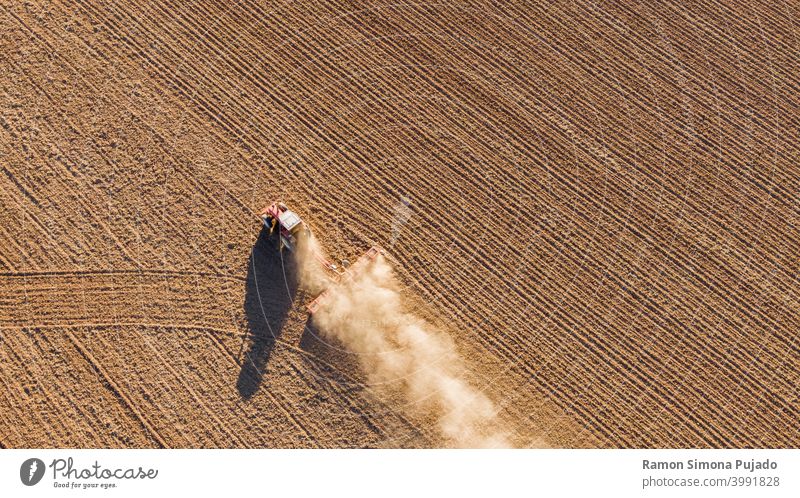 Aerial drone view of a tractor tilling the land overhead view Tractor tractors brown farming Farm Equipment fields drone photography dust rural rurally