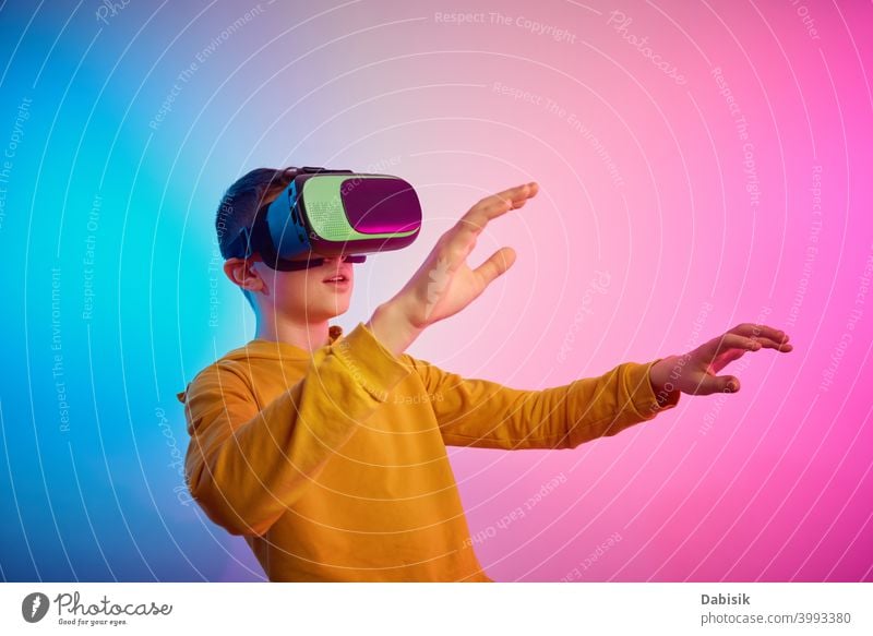 Boy with virtual reality glasses on colorful background. Future technology, VR concept vr headset boy helmet device game future video experience wearable