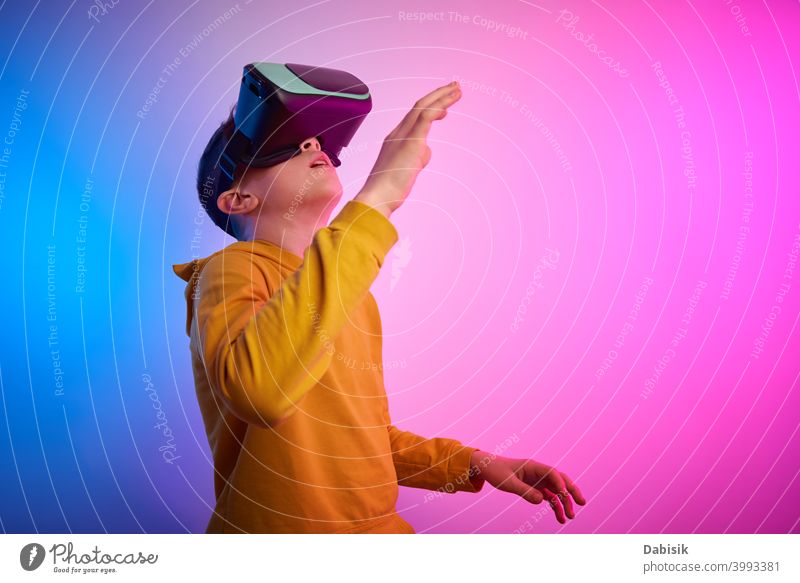 Boy with virtual reality glasses on colorful background. Future technology, VR concept vr headset boy helmet device game future video experience wearable