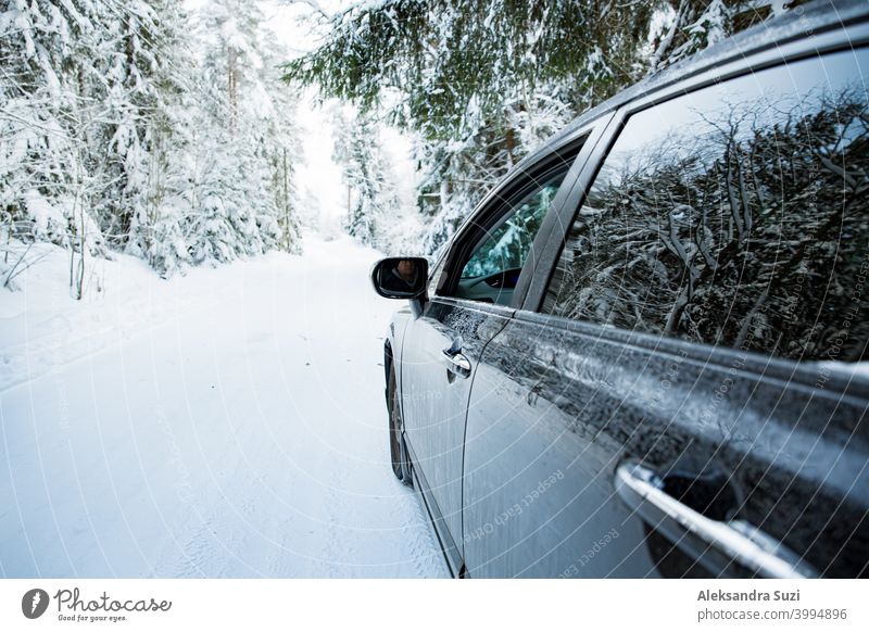 Car covered with snow and ice driving on the winter road. Beautiful landscape of winter forest and snowy country side. auto automobile blizzard car christmas