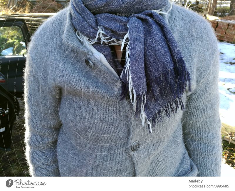 Rustic dressed woman with grey wool jacket and blue scarf with fringes in autumn in front of a farm in Rudersau near Rottenbuch in the district Weilheim-Schongau in Upper Bavaria