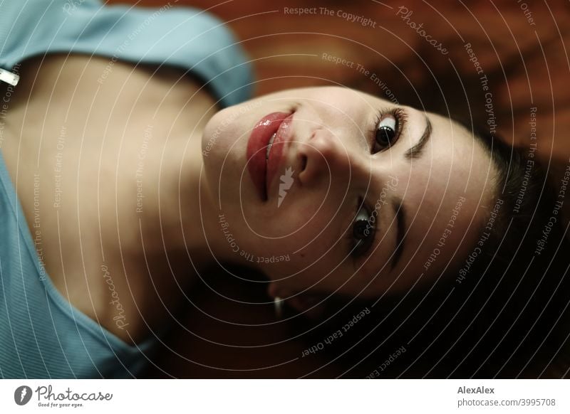 Portrait of young beautiful brunette woman lying on wooden table and looking upwards Young woman pretty Brunette Long-haired Slim teenager 18-25 years