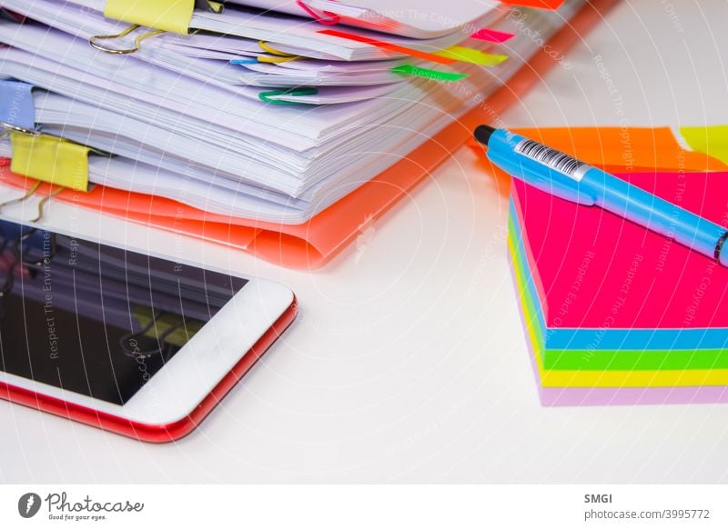 Close-up of a pile of paper with colored post its and a pen. Information overload concept information stress business datum white problem office computer