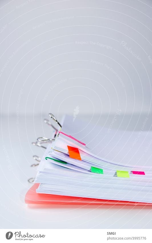 Close-up of a set of sheets attached by clips and clamps. Vertical photography. Information overload concept information stress business datum white problem