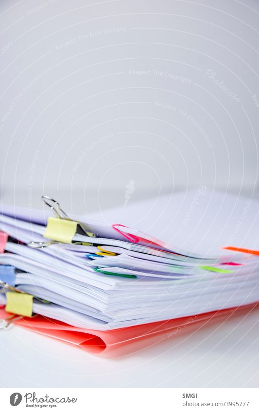 Close-up of a set of leaves attached with clips and staples. Vertical photograph. Information overload concept Overload Stress Business reference point White