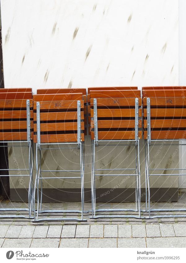 Folded beer garden chairs in front of closed catering trade Gastronomy Folding chair Closed Chair Restaurant Sidewalk café Café Deserted Exterior shot Seating