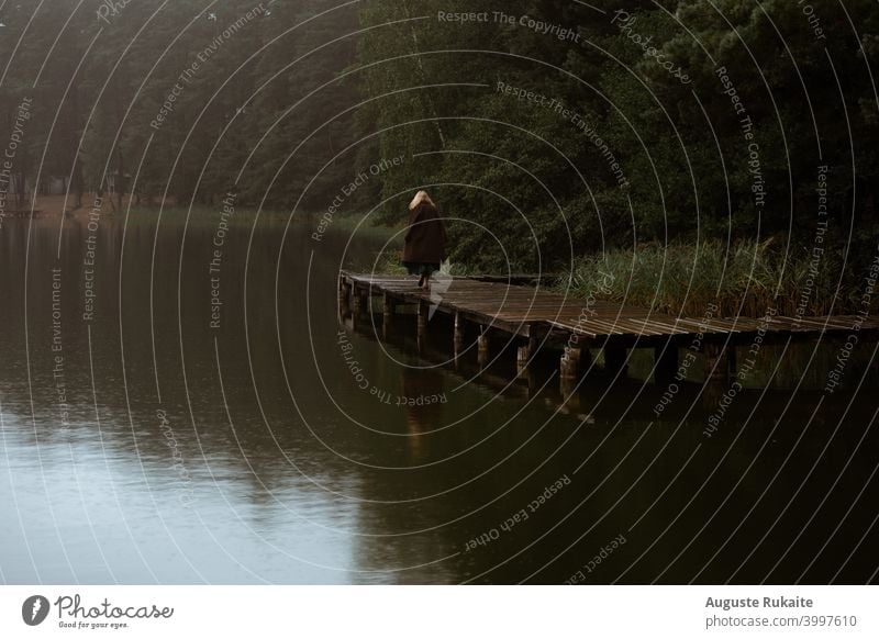 Woman standing on the footbridge in the forest rainy day raining water reflection Footbridge Water Wet Rainy weather Bad weather Autumn Exterior shot