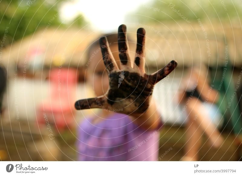 child showing a painted black palm Front view Portrait photograph Central perspective Blur Day Detail Close-up Pattern Unfriendly Black Skin color Fingers