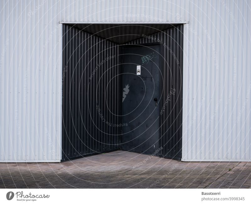 Black garage entrance on modern residential house made of white corrugated sheet metal Vitoria Basque Country Spain Spanish Underground garage Garage