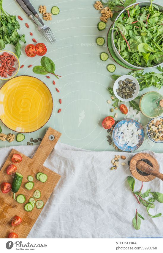 Various healthy salad ingredients on light green kitchen table background. Top view. Healthy lunch preparation, Frame various top view frame concept vegetarian