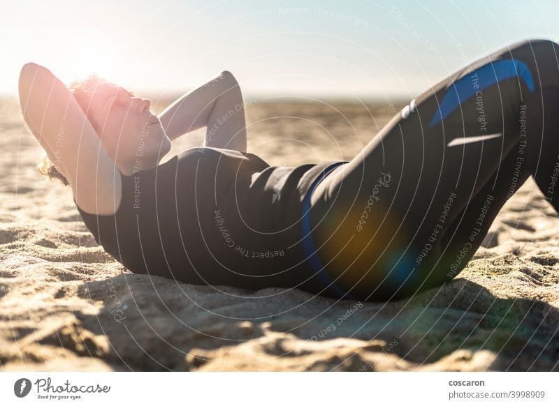 Middle aged woman doing exercise on the beach abs active adult alone athlete attractive balance beautiful blue body energy female fit fitness girl healthy