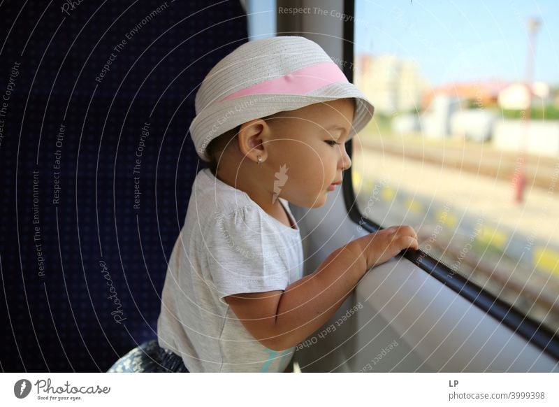 little girl wearing a hat looking outside a train window Looking away Upper body Contrast Light Copy Space bottom Structures and shapes Pattern Abstract