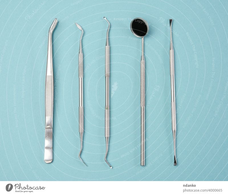 metal medical items of the dentist on a blue background teeth scraper equipment care mirror treatment clinic medicine stainless set dental professional