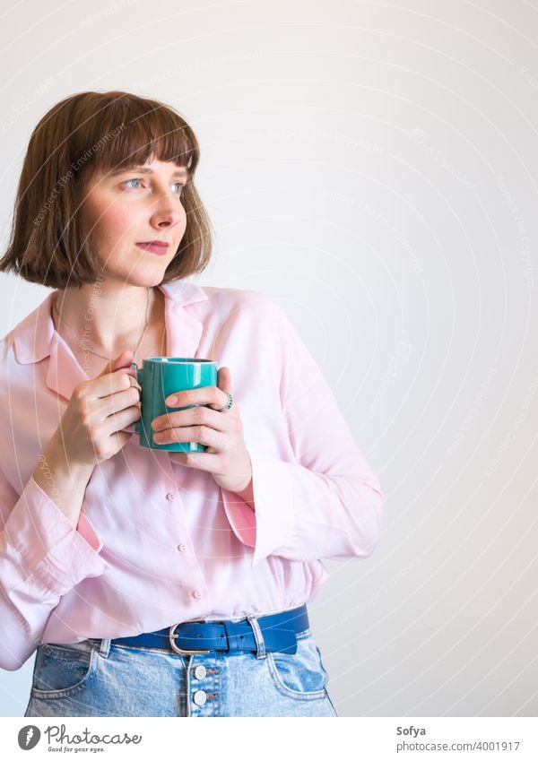 Young woman wearing pink shirt drinking coffee fashion girl face tea mug smiling cup pastel enjoy modern optimist american portrait hot lifestyle positive