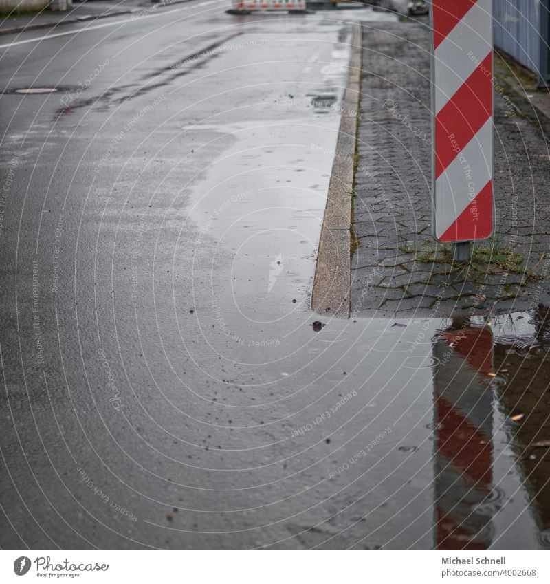 Attention: Bad weather! Rain Water Wet Weather Street Road sign esteem Construction site Exterior shot Deserted Road traffic Town Signage Warning sign