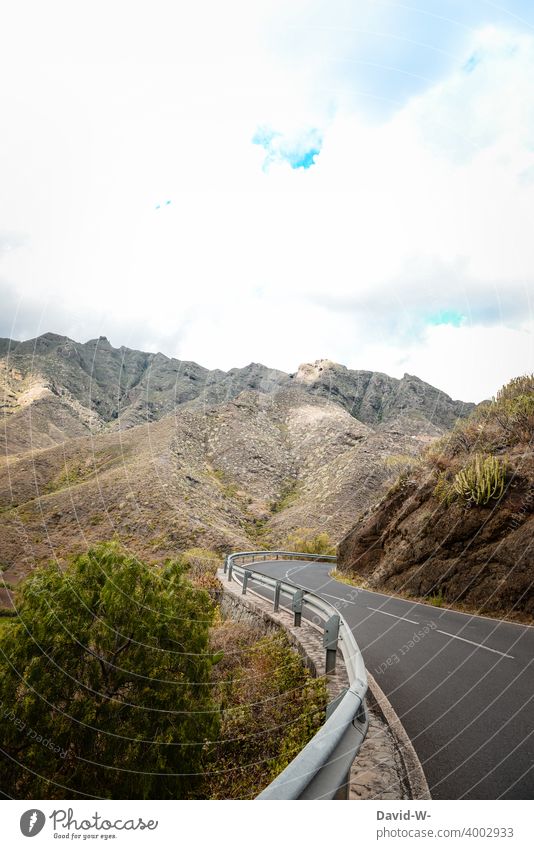 Winding road winds through the mountains curvaceous Street peril Mountain Landscape Curve Caution vacation Speed looking ahead Clouds off