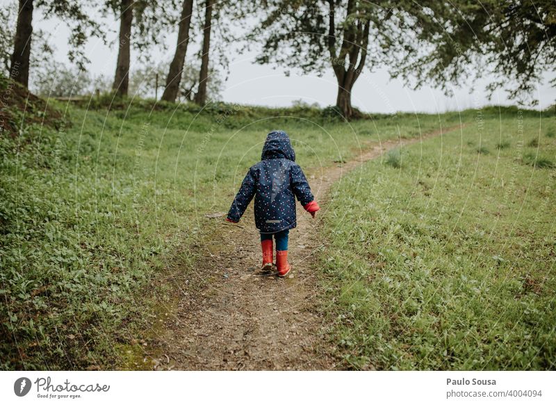 Rear view child walking in the park Child Red Rubber boots Walking Hiking Park woods Forest Authentic Infancy Playing Colour photo Boots Autumn Nature Joy Day