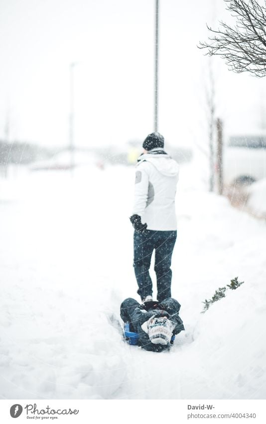 Mother pulls child with the sledge through the snow Sleigh Child Pull Winter Snow Winter's day winter White Winter mood Cold out onset of winter