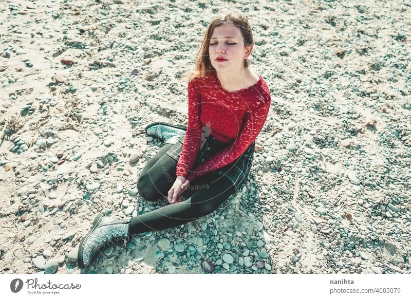 Young and trendy woman in a sunny day sitting on the beach attractive lace model fashion sand backlight red blonde sexy young youth young woman beauty beautiful