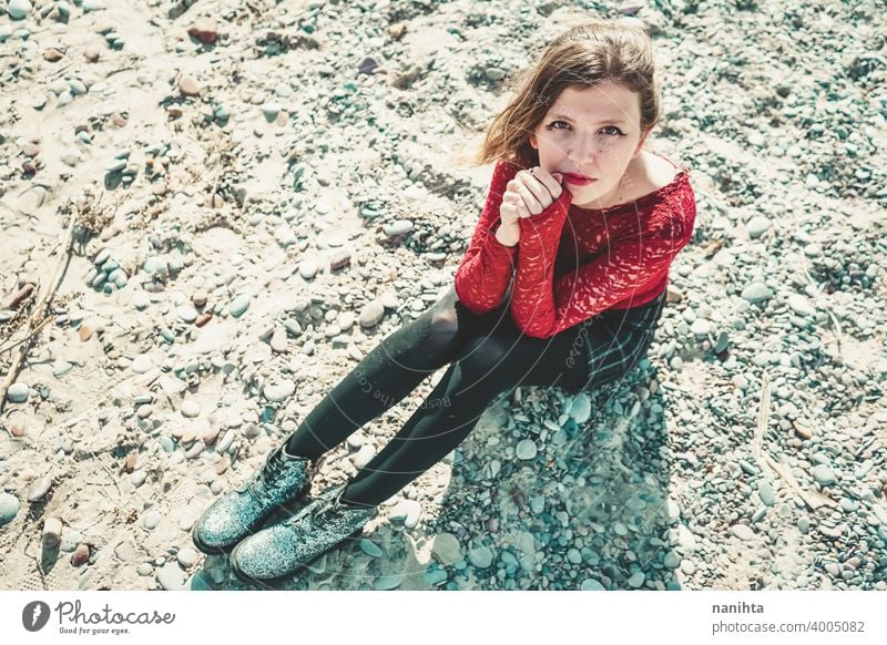 Young and trendy woman in a sunny day sitting on the beach attractive lace model fashion sand backlight red blonde sexy young youth young woman beauty beautiful