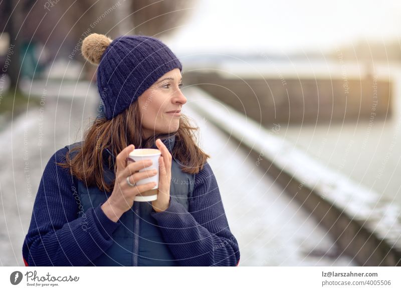 Happy middle-aged brunette woman going for a walk and drinking a coffee to go beverage outdoors tea female mature lifestyle generation european attractive mom