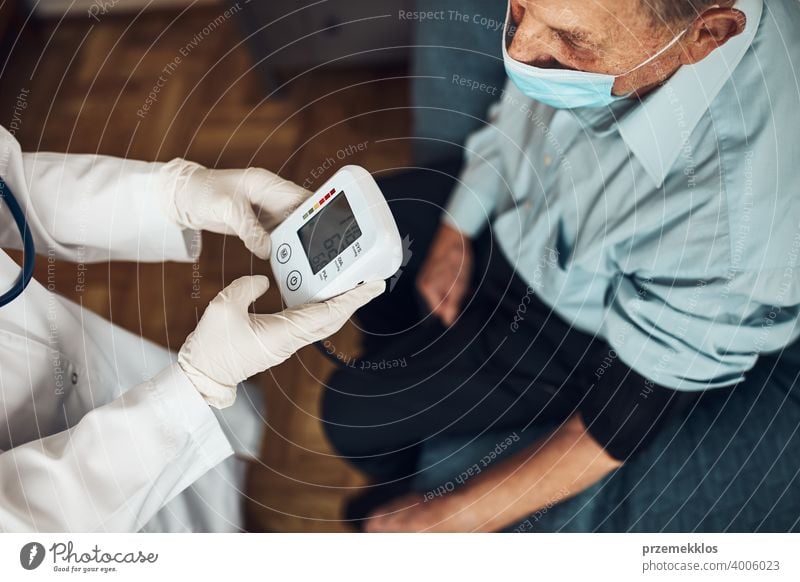 Doctor carying out blood pressure test and heart rate of senior man. Checking health condition elder patient suffering from arterial hypertension nurse check