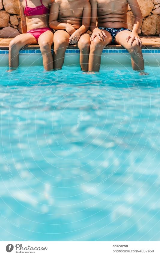 Three kids sitting on a pool´s edge active activity aqua park baby beauty blue boy child childhood children copy copy space cute enjoy family feet foot friends