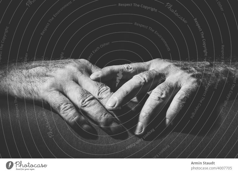 two relaxed hands lying on top of each other adult black black and white bright bw closeup contain contrast dark embrace expression finger gesture grab hold