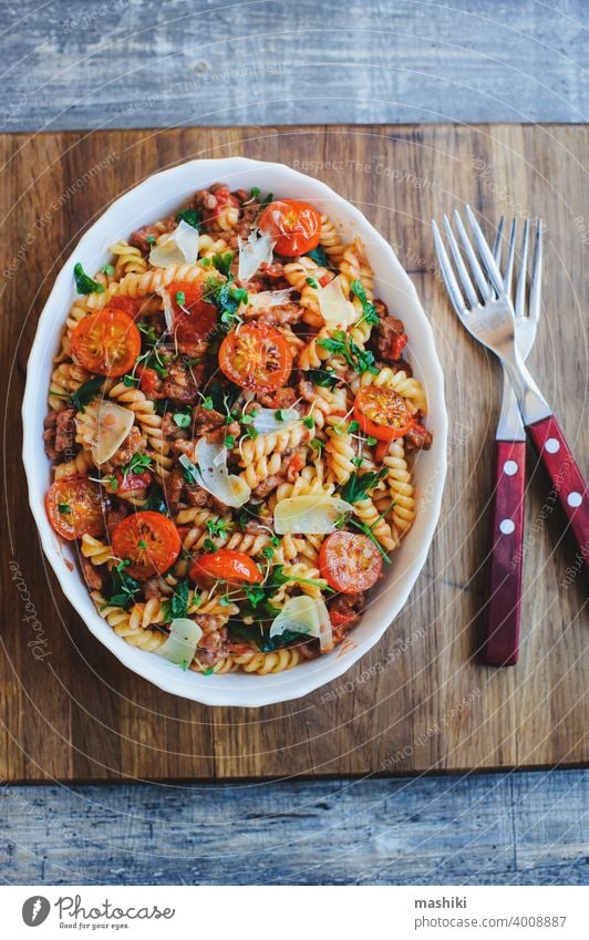 cooking tasty comfort food - italian fusilli pasta baked with meat sauce, cherry tomatoes and cheese lunch dinner plate dish vegetable basil cuisine red cooked